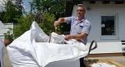 Das Foto zeigt Betriebsleiter Ralf Schmidt beim Befüllen eines Sandsacks.