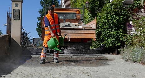 Das Foto zeigt einen Mitarbeiter des DBM beim Gießen der abgesandeten Fläche. © DBM, Sonja Stender