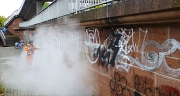 Das Foto zeigt einen Mitarbeiter des DBM bei der Beseitigung von Graffiti mit einem Dampfstrahler.