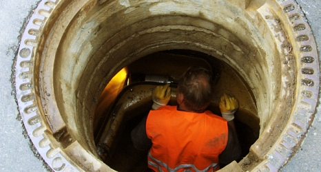 Das Foto zeigt einen Mitarbeiter des DBM mit einer Kanalkamera im Schacht.