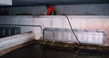 Das Foto zeigt einen Mitarbeiter des DBM beim Reinigen des Vorbeckens eines großen Regenrückhaltebeckens.
