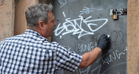 Ralf Schmidt, Leiter des DBM-Servicehofs, zeigt, wie Graffitis mit verschiedenen Flüssigleiten und Pasten entfernt werden können. © Stadt Marburg, Patricia Grähling