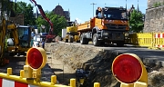 Das Foto zeigt Kräne, Bagger und LKW auf der Baustelle am rudolphsplatz.